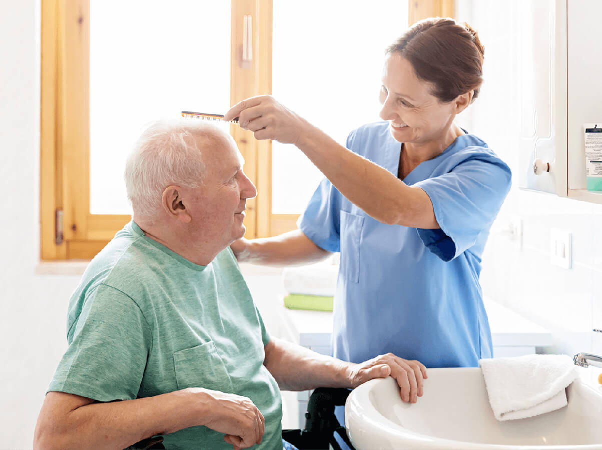 caregiver combing mans hair