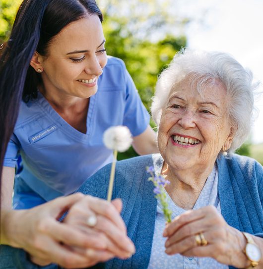 caregiver with woman and flowers